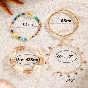 Flat lay of bohemian shell anklet set on sand with precise size specifications