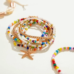 Close-up of golden starfish pendant and colorful beads on bohemian beach anklets