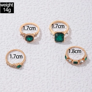 Vierteiliges goldenes Ringset mit grünen Zirkonia-Steinen und Maßangaben im Detail