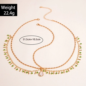 Detail of bohemian gold multi-layer necklace with green rhinestones and waterdrop pendant