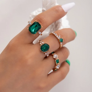 Nahaufnahme des goldenen Ring-Sets mit smaragdgrünen Edelsteinen und Zirkonia am Modell