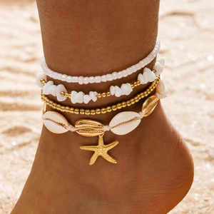 Bohemian multi-layer beach anklet set with shells, starfish, and beads on sand