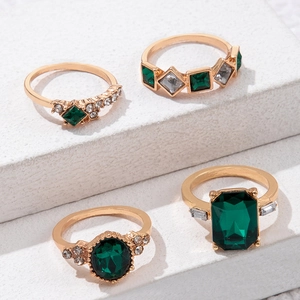Makro-Detail des vierteiligen Vintage-Goldring-Sets mit smaragdgrünen Edelsteinen