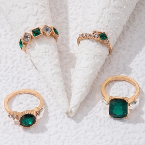 Detailansicht von vier smaragdgrünen Ringen mit Goldbeschichtung und Zirkonia-Akzenten