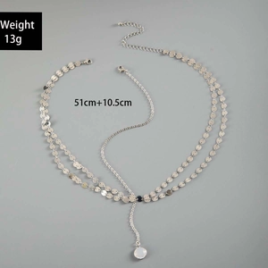 Detail of silver double-layered chain necklace with polished discs and white pendant
