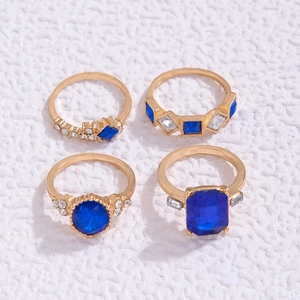 Detailansicht eines 4-teiligen Ring-Sets mit blauen Edelsteinen und goldener Politur