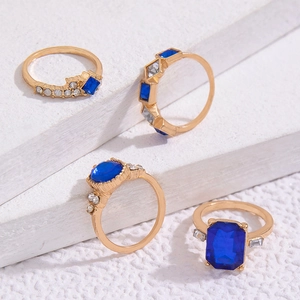 Detail von vierteiligem goldenen Ring-Set mit smaragdgeschliffenen blauen Kristallen