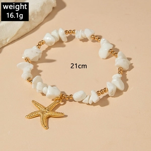 Detailed shot of bohemian beaded anklet with white turquoise stones and starfish charm