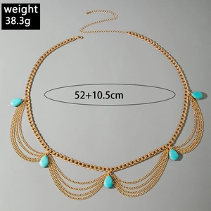 Close-up of golden multilayer chain with turquoise waterdrop pendants in boho style