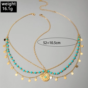 Detailed view of bohemian layered necklace with blue beads and sun pattern pendant