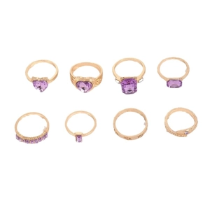 8-piece gold jewelry set with purple heart-shaped stones and snake rings on white