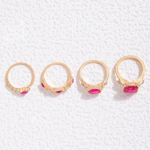 Nahaufnahme des vierteiligen Goldring-Sets mit roten Edelsteinen und Pavé-Steinen