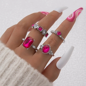 Detail eines vierteiligen Silberring-Sets mit rosa Edelsteinen an einer Hand getragen