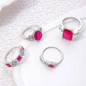 Makroaufnahme des silbernen Ringsets mit Rubinen und Pavé-Steinen auf weißer Textur