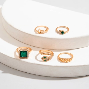 Fünfteiliges Goldring-Set mit smaragdgrünen Steinen und Love-Schriftzug im Detail