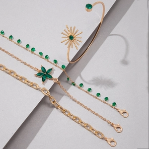 Détail du bracelet multicouche doré orné de fleurs en cristal vert et de motifs solaires