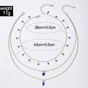 Détail d'un collier triple épaisseur avec pendentifs en cristal bleu et chaîne argent