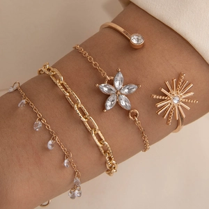 Détail d'un ensemble de cinq bracelets dorés avec fleurs en cristal et étoiles