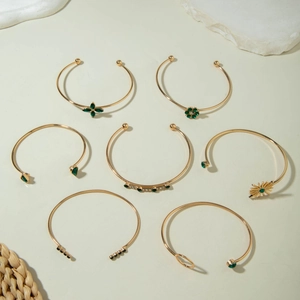 Détail d'un ensemble de 7 bracelets dorés avec pierres vert émeraude et fleurs