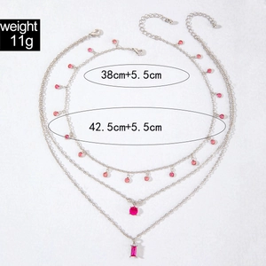 Détail du collier double couche argenté avec gemmes rouges géométriques et mesures