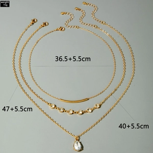 Détails du collier doré à plusieurs rangs avec pendentif goutte et cristaux