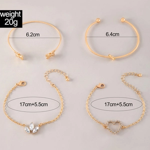 Close-up of 4-piece gold bangle set with heart charm, butterfly, and crystal leaf details