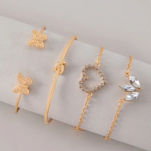 Four-piece gold bracelet set featuring butterfly cuff and heart charm with crystals