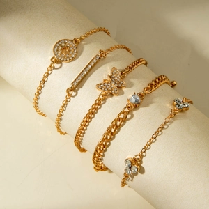 Detail of five gold bracelets with heart, butterfly and leaf motifs and sparkling crystals