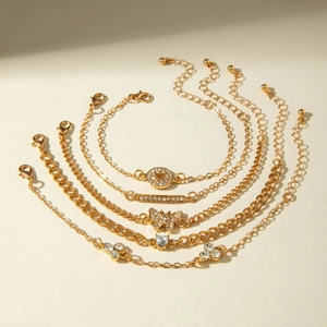 Detail of five-piece gold-tone bracelet set with crystal heart, leaf, and butterfly charms