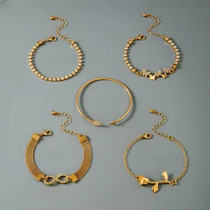 Detail of five gold bracelets set with butterfly charms and dimensions on gray background