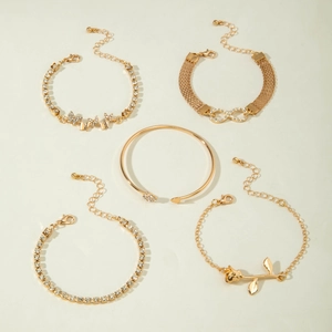 Close-up of a 5-piece gold bracelet set featuring heart leaf motifs and crystal butterfly knot