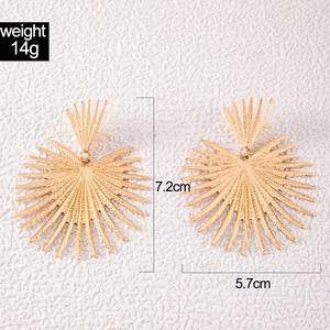 Detail of gold sunflower earrings showing 7.2cm length and metal texture details