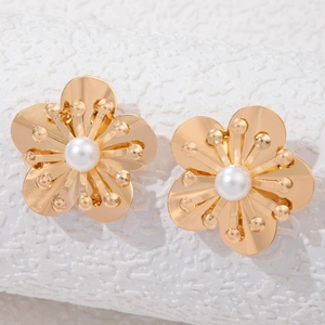 Macro detail of gold flower earrings with white pearl center and 3D petal texture