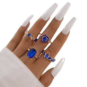 Ensemble de quatre bagues dorées avec cœurs en saphir bleu et designs géométriques