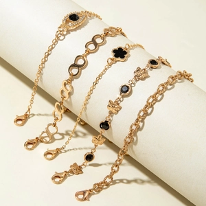 Détail d'un ensemble de cinq bracelets dorés avec breloques œil et papillon