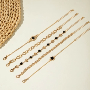 Détail du lot de cinq bracelets dorés avec breloques papillon, mauvais œil et trèfle