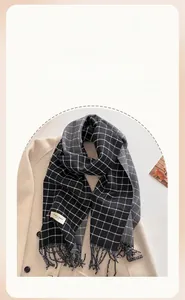 Detail of grey plaid scarf with Elegant & Classic woven label and soft fringe trim