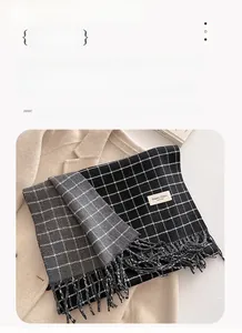 Detail showing high-density tassels and classic plaid pattern on the thick winter scarf