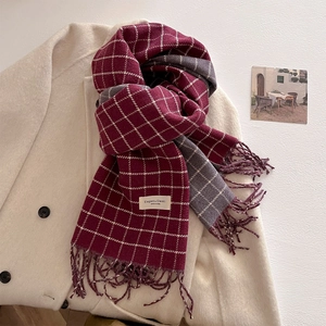 Detailed view of the soft wine red and grey plaid scarf with fringe and classic label