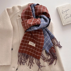 Detail of plaid scarf with tassels on beige wool coat featuring elegant fabric label