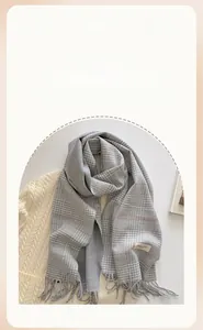 Close-up of grey and white plaid scarf featuring soft fringe and pink pinstripe details