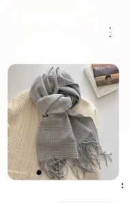 Detail of grey plaid winter scarf with fringe tassels and Elegant & Classic woven label