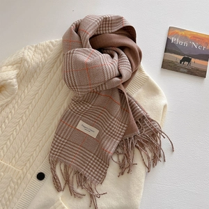 Close-up of thick winter scarf with vintage brown houndstooth pattern and fringe detail