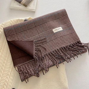 Close-up of thick dark brown glen plaid scarf with tassels and elegant woven label