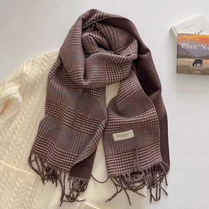 Close-up of retro plaid scarf with long tassels and elegant classic woven label