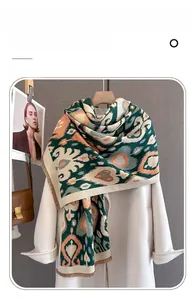 Detailed texture of thick imitation cashmere scarf with orange and green paisley print