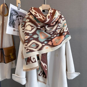 Close-up of vintage geometric heart pattern scarf with tassels on white coat