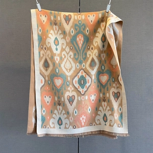 Detailed view of vintage heart pattern scarf with warm brown tones and fringe tassels