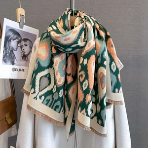 Close-up of thick paisley scarf with fringe details on a stylish wool coat
