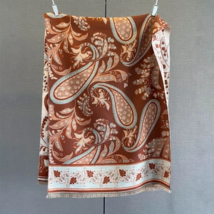 Close-up of thick paisley cashmere feel shawl with fringe in dark brown and beige colors